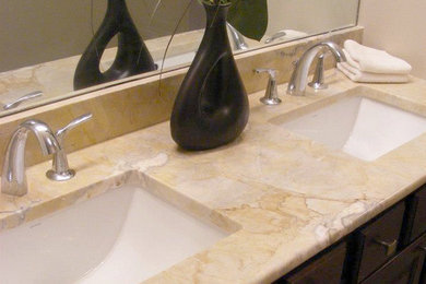 Foto de cuarto de baño principal con lavabo bajoencimera, armarios con paneles con relieve, puertas de armario de madera en tonos medios, encimera de mármol y paredes beige