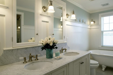 Inredning av ett klassiskt mycket stort en-suite badrum, med vita skåp, ett badkar med tassar, skåp i shakerstil, blå väggar, ett undermonterad handfat och marmorbänkskiva