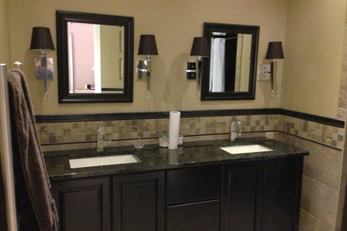 Example of a mid-sized trendy beige tile and ceramic tile bathroom design in Other with raised-panel cabinets, black cabinets, beige walls, an undermount sink and granite countertops
