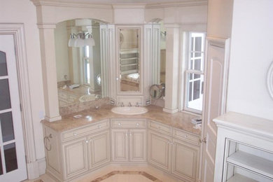 Example of a large classic master beige tile and porcelain tile marble floor drop-in bathtub design in Boston with raised-panel cabinets, white cabinets, marble countertops, white walls and a two-piece toilet