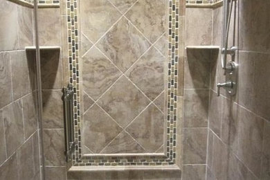 ボルチモアにある広いトラディショナルスタイルのおしゃれなマスターバスルーム (アルコーブ型シャワー、茶色いタイル、磁器タイル、茶色い壁、玉石タイル、マルチカラーの床、開き戸のシャワー) の写真