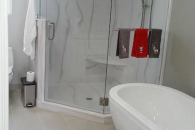 Foto de cuarto de baño principal minimalista de tamaño medio con bañera exenta, ducha esquinera, paredes grises y suelo vinílico
