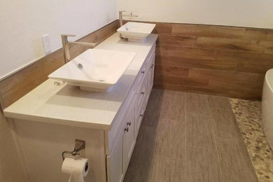 Idéer för ett mellanstort modernt vit en-suite badrum, med luckor med infälld panel, vita skåp, ett fristående badkar, brun kakel, vita väggar, klinkergolv i porslin, ett fristående handfat, bänkskiva i kvarts och brunt golv