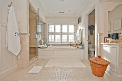ニューヨークにあるコンテンポラリースタイルのおしゃれなマスターバスルーム (白いキャビネット、ドロップイン型浴槽、アルコーブ型シャワー、ベージュのタイル、磁器タイル、白い壁、磁器タイルの床) の写真