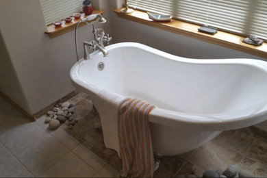 Modelo de cuarto de baño tradicional renovado de tamaño medio con bañera con patas, paredes grises y suelo de baldosas de cerámica