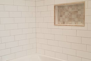 Bathroom - mid-sized transitional 3/4 white tile and subway tile mosaic tile floor and white floor bathroom idea in Other with shaker cabinets, white cabinets, a two-piece toilet, beige walls, an undermount sink, solid surface countertops and white countertops