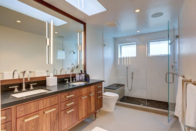 Large minimalist master white tile and porcelain tile porcelain tile and beige floor alcove shower photo in San Francisco with furniture-like cabinets, medium tone wood cabinets, a one-piece toilet, white walls, an undermount sink, granite countertops and a hinged shower door