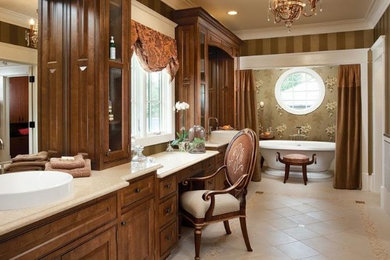 Ejemplo de cuarto de baño clásico con lavabo encastrado, puertas de armario de madera en tonos medios, bañera exenta, sanitario de dos piezas, baldosas y/o azulejos beige y paredes multicolor