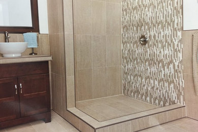 Small trendy 3/4 beige tile and matchstick tile ceramic tile and beige floor corner shower photo in Nashville with recessed-panel cabinets, dark wood cabinets, beige walls, a vessel sink and tile countertops