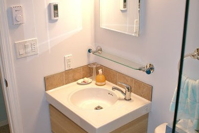 Bild på ett litet funkis badrum med dusch, med släta luckor, en toalettstol med separat cisternkåpa, beige kakel, blå väggar, klinkergolv i keramik, ett integrerad handfat, bänkskiva i kvarts, skåp i ljust trä, en dusch i en alkov och keramikplattor