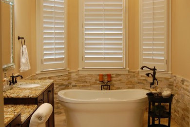 Freestanding bathtub - mid-sized traditional master beige tile and stone tile porcelain tile and beige floor freestanding bathtub idea in Orlando with flat-panel cabinets, dark wood cabinets, beige walls, an undermount sink and granite countertops
