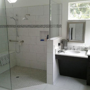 Large trendy master white tile and porcelain tile porcelain tile and white floor bathroom photo in Orlando with recessed-panel cabinets, dark wood cabinets, white walls, an undermount sink and solid surface countertops