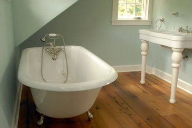 Claw-foot bathtub - traditional medium tone wood floor claw-foot bathtub idea in Bridgeport with green walls, a console sink and solid surface countertops