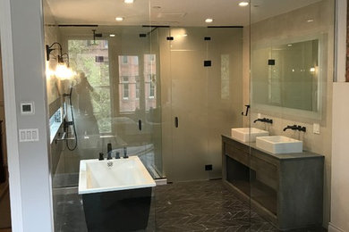 Inspiration for a large modern master black floor and ceramic tile bathroom remodel in Atlanta with flat-panel cabinets, gray cabinets, beige walls, a vessel sink, wood countertops, a hinged shower door and black countertops