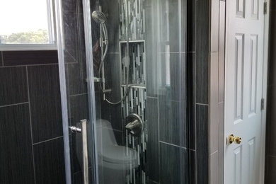 Diseño de cuarto de baño moderno de tamaño medio con ducha empotrada, baldosas y/o azulejos blancas y negros, baldosas y/o azulejos grises, azulejos en listel, paredes marrones, suelo laminado, aseo y ducha, suelo beige y ducha con puerta corredera