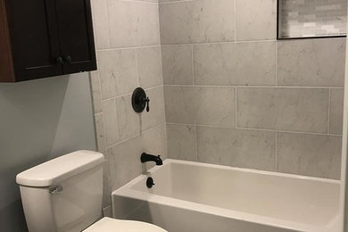 Diseño de cuarto de baño clásico renovado de tamaño medio con bañera empotrada, baldosas y/o azulejos grises, baldosas y/o azulejos de cerámica y aseo y ducha