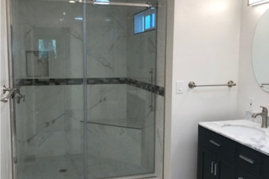 This is an example of a medium sized traditional ensuite bathroom in San Francisco with dark wood cabinets, a corner shower, grey tiles, white tiles, marble tiles, white walls, marble flooring, a submerged sink, marble worktops, grey floors, a sliding door and grey worktops.