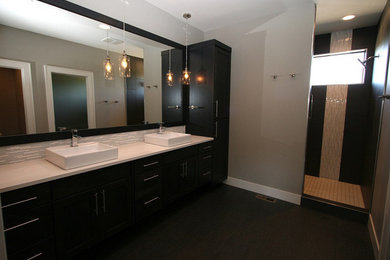 Example of a mid-sized minimalist master ceramic tile bathroom design in Phoenix with flat-panel cabinets, dark wood cabinets, gray walls, a vessel sink and solid surface countertops