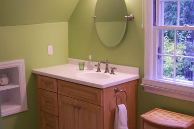 ニューヨークにあるお手頃価格の中くらいなトラディショナルスタイルのおしゃれなバスルーム (浴槽なし) (落し込みパネル扉のキャビネット、淡色木目調キャビネット、緑の壁、セラミックタイルの床、一体型シンク、人工大理石カウンター) の写真