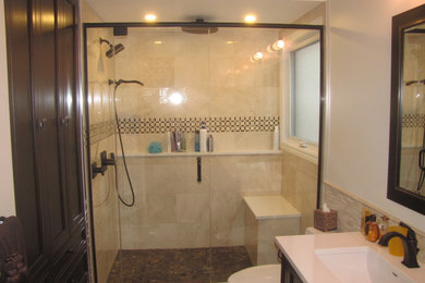トロントにある中くらいなトラディショナルスタイルのおしゃれな浴室 (濃色木目調キャビネット、アルコーブ型シャワー、ベージュのタイル、アンダーカウンター洗面器) の写真