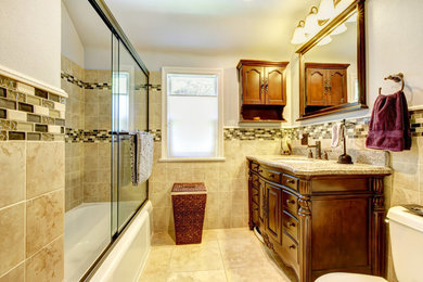 Bathroom - small transitional kids' beige tile and ceramic tile ceramic tile and beige floor bathroom idea in Providence with furniture-like cabinets, dark wood cabinets, a two-piece toilet, gray walls, an undermount sink, granite countertops and multicolored countertops
