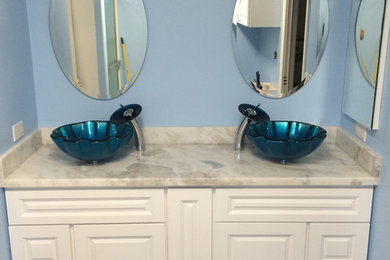 Foto de cuarto de baño principal clásico renovado con armarios con paneles con relieve, puertas de armario blancas, paredes azules, lavabo sobreencimera y encimera de mármol