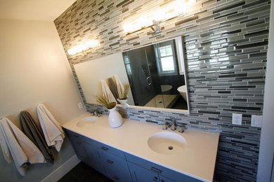 Example of a mid-sized trendy master white tile and porcelain tile porcelain tile alcove shower design in Salt Lake City with flat-panel cabinets, white cabinets, a two-piece toilet, white walls, an integrated sink and solid surface countertops