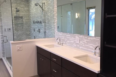 Inspiration for a large contemporary ensuite bathroom in Chicago with flat-panel cabinets, dark wood cabinets, an alcove shower, grey tiles, white tiles, glass tiles, grey walls, porcelain flooring, a submerged sink, quartz worktops, beige floors and a hinged door.