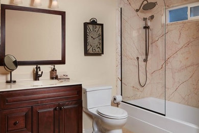 アトランタにある広いトラディショナルスタイルのおしゃれなバスルーム (浴槽なし) (レイズドパネル扉のキャビネット、濃色木目調キャビネット、アルコーブ型浴槽、シャワー付き浴槽	、分離型トイレ、ベージュのタイル、ピンクのタイル、赤いタイル、石スラブタイル、ベージュの壁、セラミックタイルの床、一体型シンク、人工大理石カウンター、ベージュの床、オープンシャワー) の写真