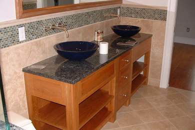 Mid-sized elegant ceramic tile and beige floor bathroom photo in Baltimore with flat-panel cabinets, medium tone wood cabinets, a vessel sink and granite countertops