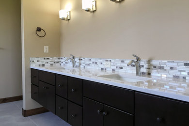 Bathroom - mid-sized transitional 3/4 beige tile, brown tile and ceramic tile marble floor and white floor bathroom idea in Other with flat-panel cabinets, dark wood cabinets, a two-piece toilet, beige walls, an undermount sink and solid surface countertops