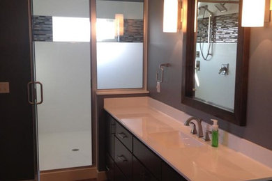 他の地域にあるおしゃれな浴室 (レイズドパネル扉のキャビネット、中間色木目調キャビネット、アルコーブ型シャワー、ベージュのタイル、セラミックタイル、白い壁、無垢フローリング) の写真
