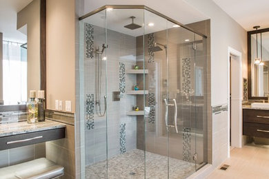 Inspiration for a large classic ensuite bathroom in New Orleans with flat-panel cabinets, dark wood cabinets, a corner shower, grey tiles, porcelain tiles, brown walls, porcelain flooring, granite worktops, beige floors and a hinged door.