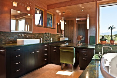 アルバカーキにある中くらいなコンテンポラリースタイルのおしゃれなマスターバスルーム (ベッセル式洗面器、フラットパネル扉のキャビネット、黒いキャビネット、ドロップイン型浴槽、緑のタイル、茶色い壁) の写真