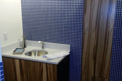 Imagen de cuarto de baño tradicional renovado de tamaño medio con baldosas y/o azulejos azules, paredes blancas, armarios con paneles lisos, puertas de armario de madera oscura, baldosas y/o azulejos en mosaico, lavabo bajoencimera y encimera de cuarzo compacto