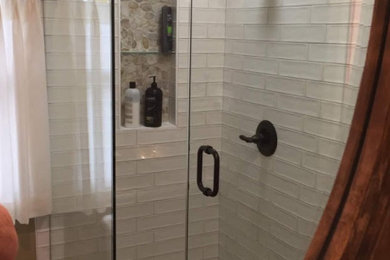 Small elegant master white tile and ceramic tile porcelain tile and black floor corner shower photo in Kansas City with furniture-like cabinets, black cabinets, a two-piece toilet, beige walls, a vessel sink, granite countertops and multicolored countertops
