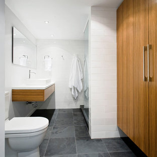 Modelo de cuarto de baño vestidor y gris y blanco, minimalista, con lavabo sobreencimera, suelo de pizarra y suelo gris