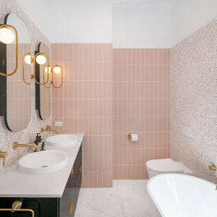 Large contemporary master bathroom in Brisbane with furniture-like cabinets, black cabinets, a freestanding tub, an open shower, a wall-mount toilet, pink tile, mosaic tile, pink walls, ceramic floors, a vessel sink, marble benchtops, black floor, an open shower, white benchtops, a niche, a double vanity and a floating vanity.