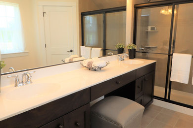 Example of a large master gray tile double-sink sliding shower door design in Philadelphia with shaker cabinets, brown cabinets, an integrated sink and a freestanding vanity