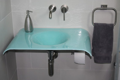 Modelo de cuarto de baño actual con baldosas y/o azulejos blancos, baldosas y/o azulejos de porcelana, paredes blancas, lavabo integrado y encimera de vidrio