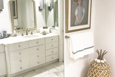 Inspiration for a mid-sized coastal master marble floor and white floor bathroom remodel in Miami with beaded inset cabinets, white cabinets, gray walls, marble countertops and white countertops