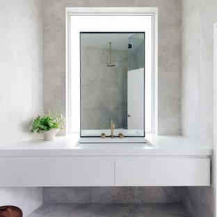 Design ideas for a beach style bathroom in Sydney with flat-panel cabinets, white cabinets, gray tile, grey walls, an undermount sink, grey floor and white benchtops.