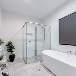 Design ideas for a contemporary master bathroom in Sunshine Coast with a freestanding tub, a corner shower, gray tile, white walls, grey floor and a hinged shower door.