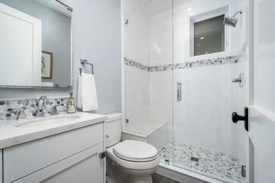 Transitional ceramic tile ceramic tile and gray floor corner shower photo in San Francisco with white cabinets, a two-piece toilet, gray walls, an undermount sink, quartz countertops, a hinged shower door and white countertops