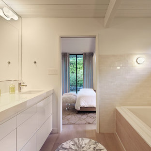 Inspiration for a mid-century modern beige tile and subway tile drop-in bathtub remodel in San Francisco with flat-panel cabinets and white cabinets