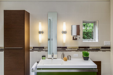Diseño de cuarto de baño principal moderno de tamaño medio con lavabo integrado, puertas de armario verdes, ducha esquinera, sanitario de pared, baldosas y/o azulejos marrones, baldosas y/o azulejos de porcelana, paredes blancas y suelo de baldosas de porcelana