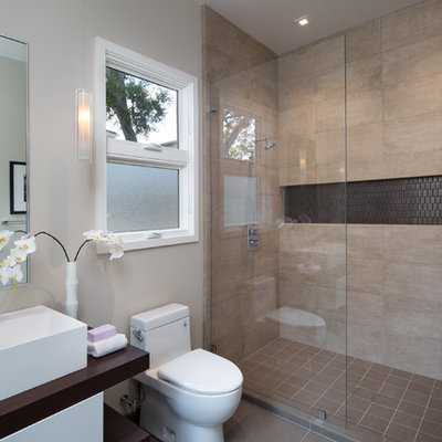Example of a mid-sized trendy 3/4 beige tile and ceramic tile porcelain tile and brown floor alcove shower design in San Francisco with flat-panel cabinets, white cabinets, a one-piece toilet, white walls, a vessel sink, wood countertops, a hinged shower door and brown countertops