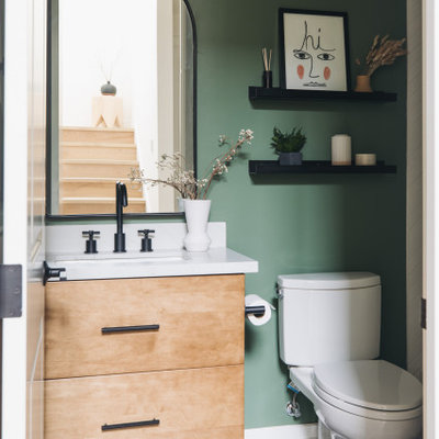 Inspiration for a small contemporary white tile and subway tile porcelain tile, black floor and single-sink bathroom remodel in San Francisco with flat-panel cabinets, medium tone wood cabinets, a two-piece toilet, green walls, an undermount sink, quartz countertops, a hinged shower door, white countertops and a floating vanity