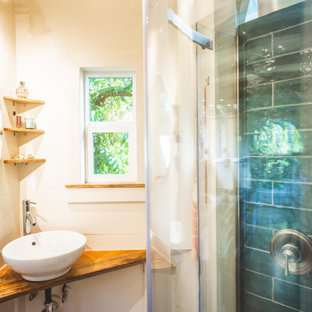 Small beach style 3/4 blue tile and ceramic tile laminate floor, beige floor, single-sink and vaulted ceiling bathroom photo in Hawaii with open cabinets, beige cabinets, a one-piece toilet, beige walls, a vessel sink, wood countertops, beige countertops, a niche and a built-in vanity