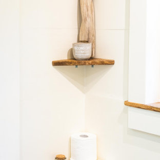 Example of a small beach style 3/4 blue tile and ceramic tile laminate floor, beige floor, single-sink and vaulted ceiling bathroom design in Hawaii with open cabinets, beige cabinets, a one-piece toilet, beige walls, a vessel sink, wood countertops, beige countertops, a niche and a built-in vanity